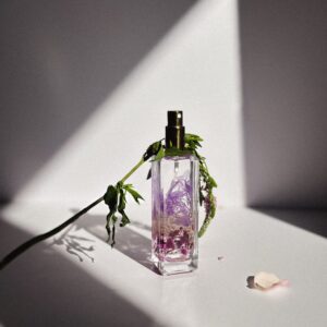 A beautifully crafted perfume bottle with delicate florals and dramatic shadows.
